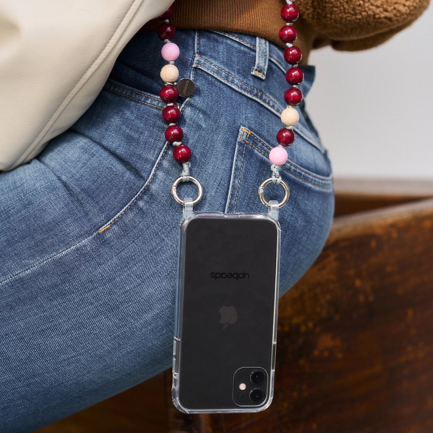 model wears around her shoulder an Autumn upbeads cellphone chain attached to it a cellphone case with rings