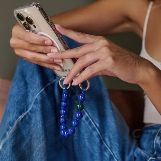 model is wearing a mini rainbow upbeads as a bracelet and an ocean model mini upbeads as a cellphone case