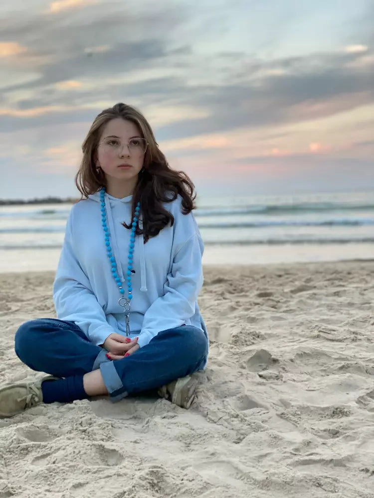 THE EYE MIDI cell phone chain / key chain MIDI UPBEADS girl sitting at the beach in Tel Aviv wearing upbeads midi the eye light blue as a key chain