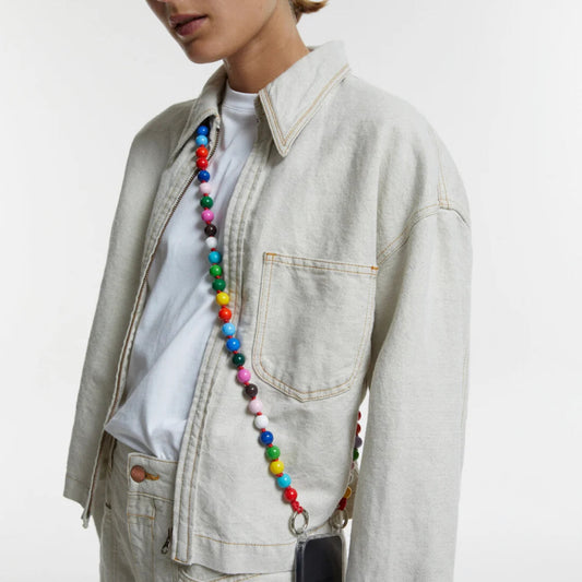 Person wearing a colorful wooden bead crossbody upbeads cellphone chain with a plain background
