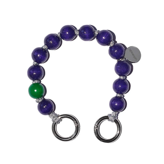 plum mini keychain with dark purple wooden beads on grey cord with green signature bead on white background