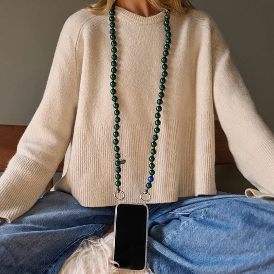 model is wearing a crossbody upbeads 120cm as a necklace junglebeads attached to an upbeads phone case