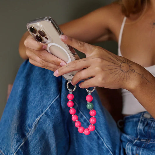 model holding an iphone with upbeads case attached to a mini pink lady upbeads
