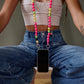 flashdance cellphone chain with case upbeads worn as a necklace size is 120cm crossbody pink and yellow and lime colors worn on a model blue jeans and white top