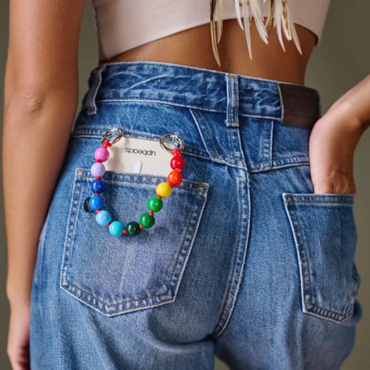 model back pocket carrying an upbeads mini rainbow attached to an upbeads phone case used as a phone chain