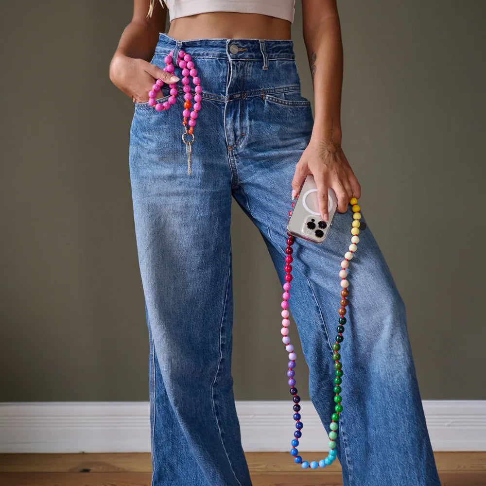 model holding an upbeads model rainbow as a cellphone chain 120cm and on the other side an upbeads Shortie model love is slipped through the jeans as a keychain