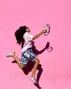 midi junglebeads upbeads attached to ipone while girl jumps with pink background