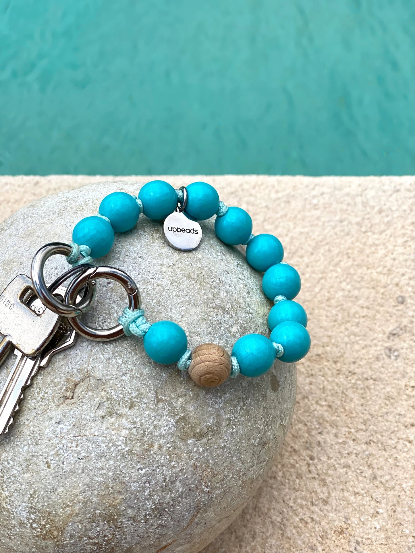 mini Bahamas on a stone at a pool in summer used as a keychain turquoise
