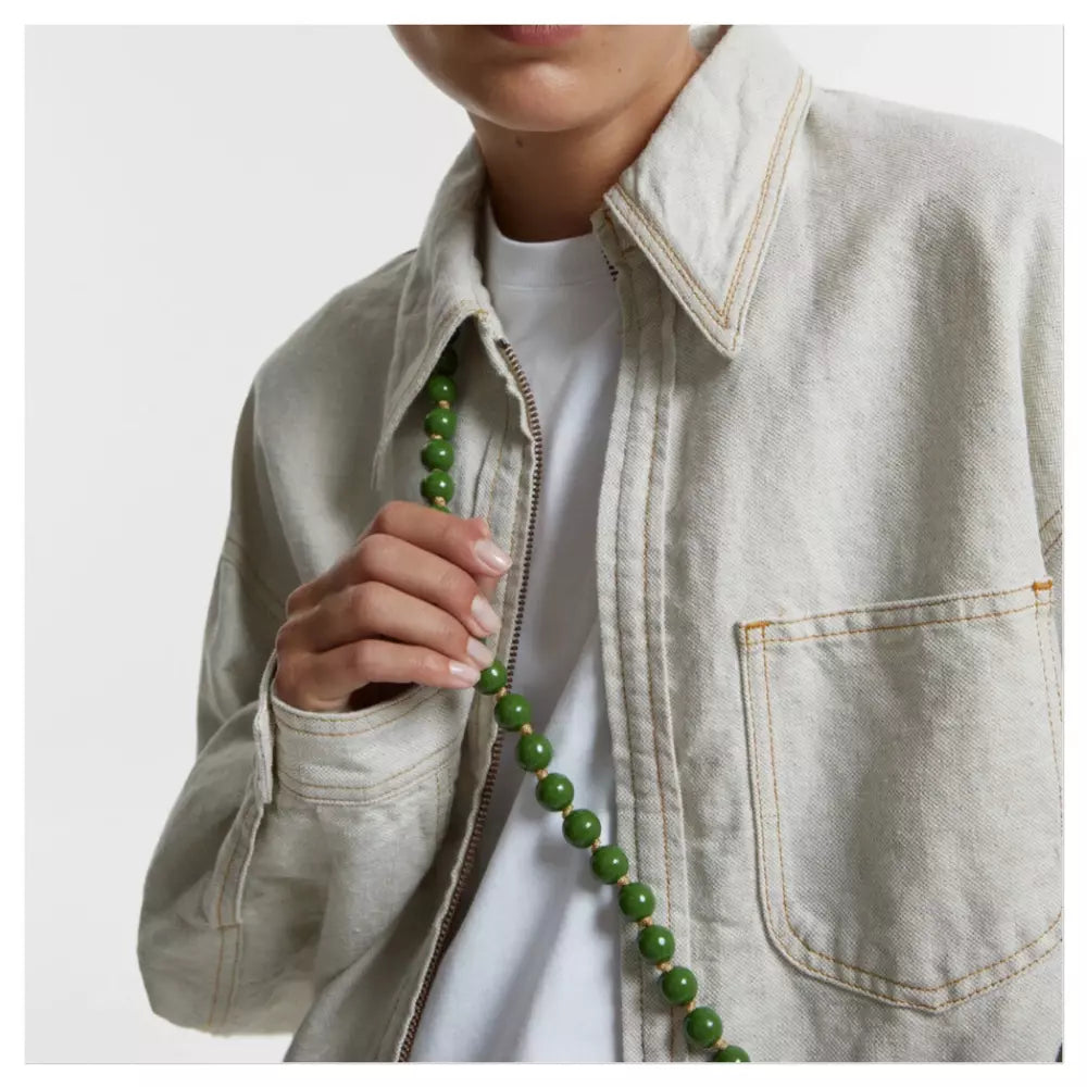 upbeads crossbody cellphone chain worn by model olive green wooden beads on creme white jeans jacket CLOSED model