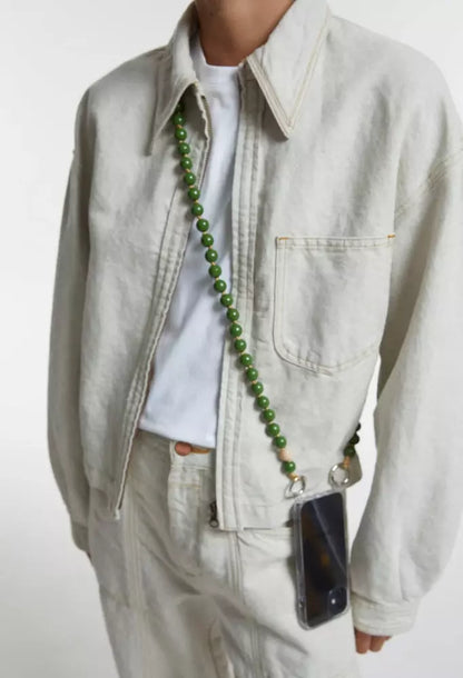 crossbody upbeads cellphone chain in olive green wooden beads worn by CLOSED model creme white jeans and creme white jeans jacket