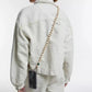 upbeads crossbody cellphone chain on woman dressed in white jeans and white closed jeans jacket crossbody
