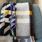 Violet / wisteria color wooden beaded crossbody necklace with used as glasses holder patterned fabric background