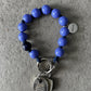 Violet-Blue wooden beaded upbeads keychain on a textured surface